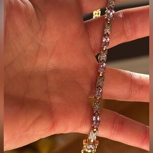 Costume jewelry bracelet gold with light purple “gemstones”. Approx. 7.5 inches.